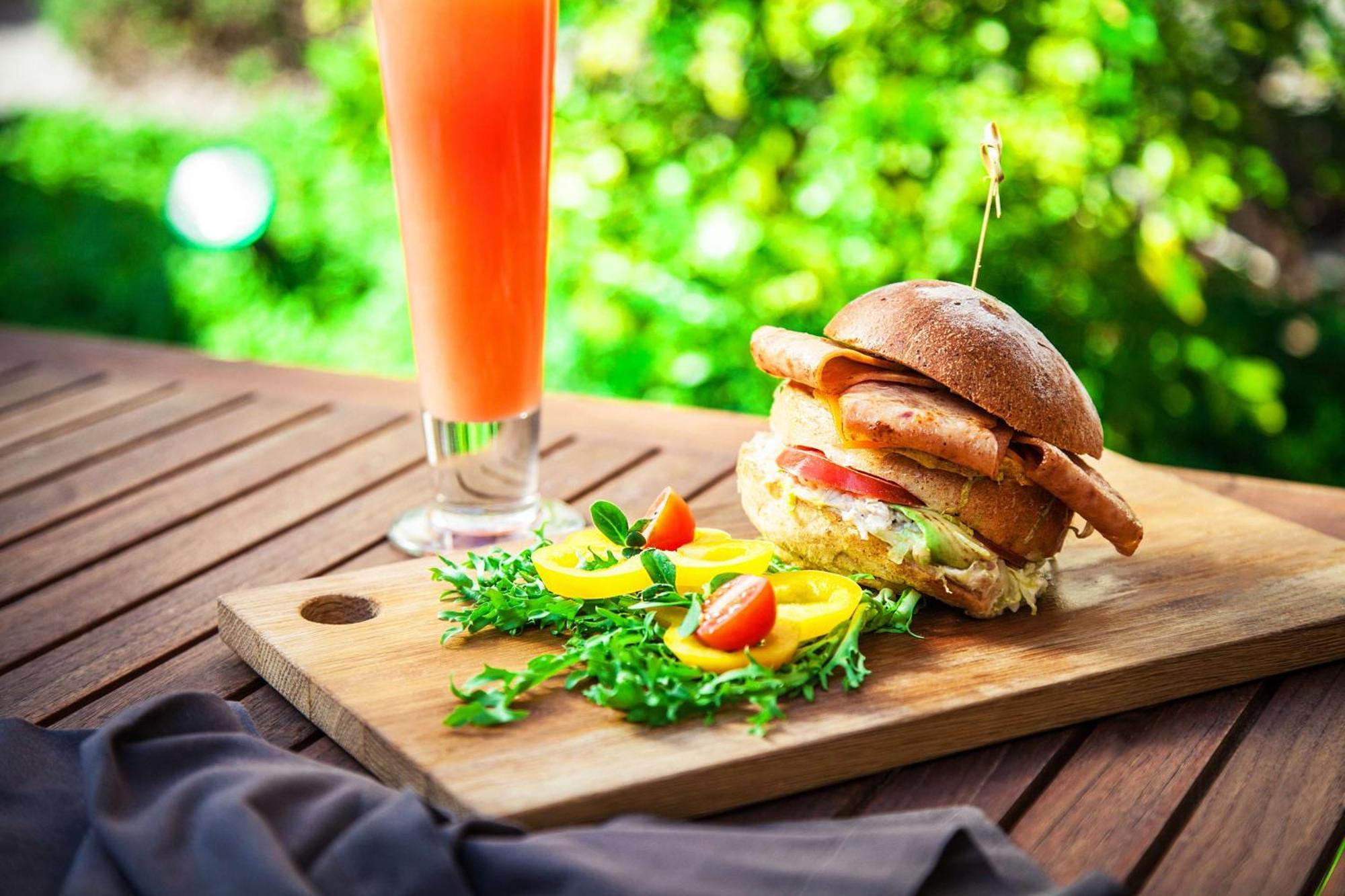 Radisson Blu Hotel, Dubai Deira Creek Esterno foto A chicken burger with a glass of orange juice