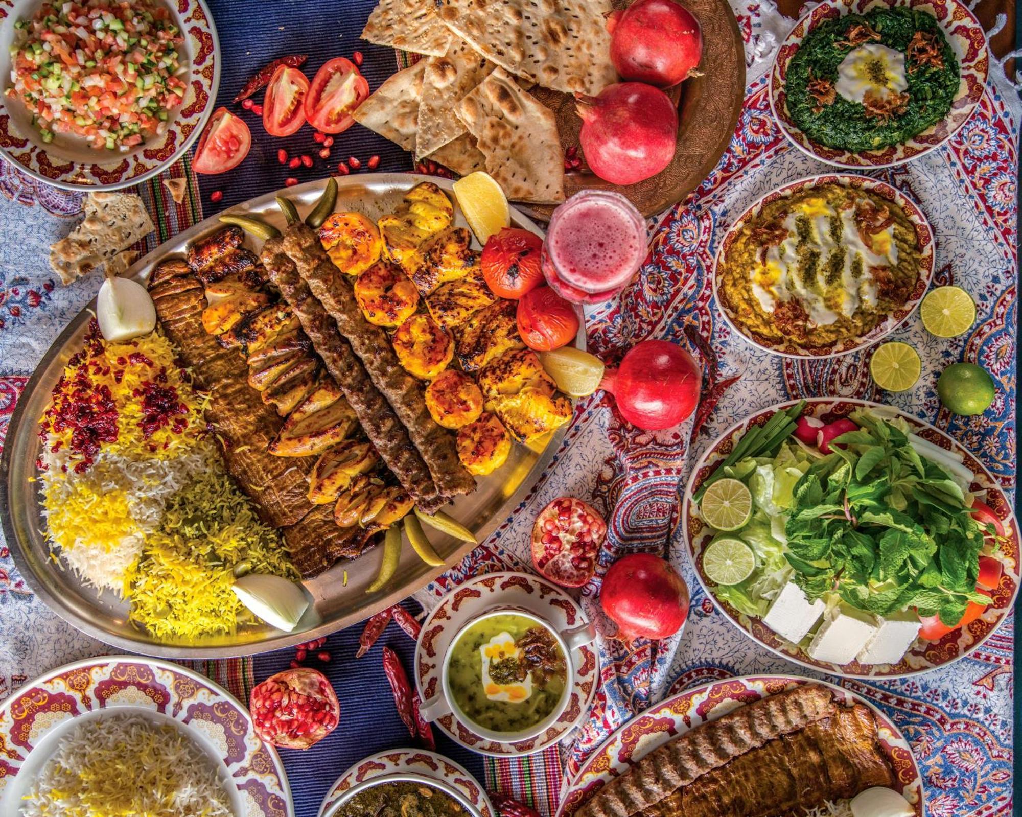 Radisson Blu Hotel, Dubai Deira Creek Esterno foto The photo displays a vibrant spread of various dishes set on a decorative tablecloth. Central to the arrangement is a large platter featuring grilled meats, including kebabs, along with shrimp, garnished with lemons and accompanied by colorful rice. 